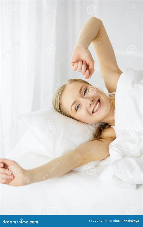 Smiling Woman Stretching Hands In Bed After Waking Up Entering A Day