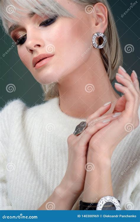 La Blonde Avec Un Bel Anneau Et Des Boucles D Oreille Posant Dans Le Studio Sur Un Fond Vert