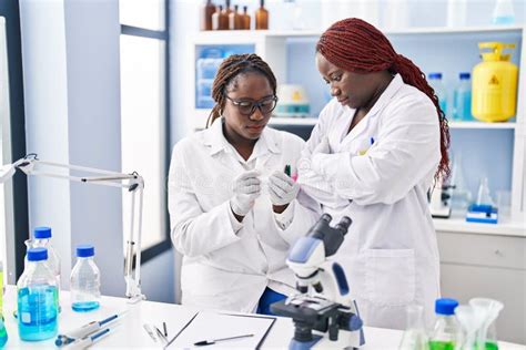 African American Women Scientists Looking Sample Standing With Arms