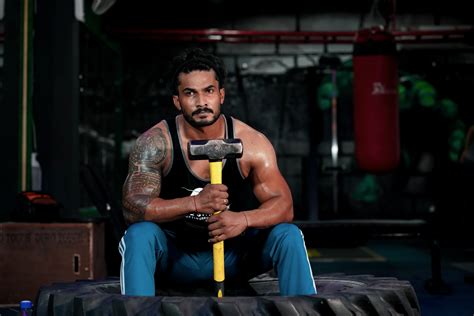 Bodybuilder holding a hammer at gym - PixaHive