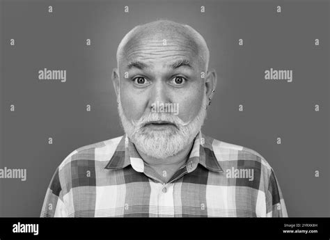 Portrait Of An Surprised Bald Old Mature Senior Man With Grey Beard In Shirt Isolated On Blue