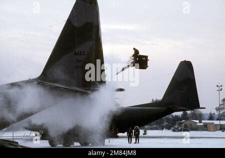 A USAF Ground Crewman Deices The Wing Of A C 130 Hercules Cargo