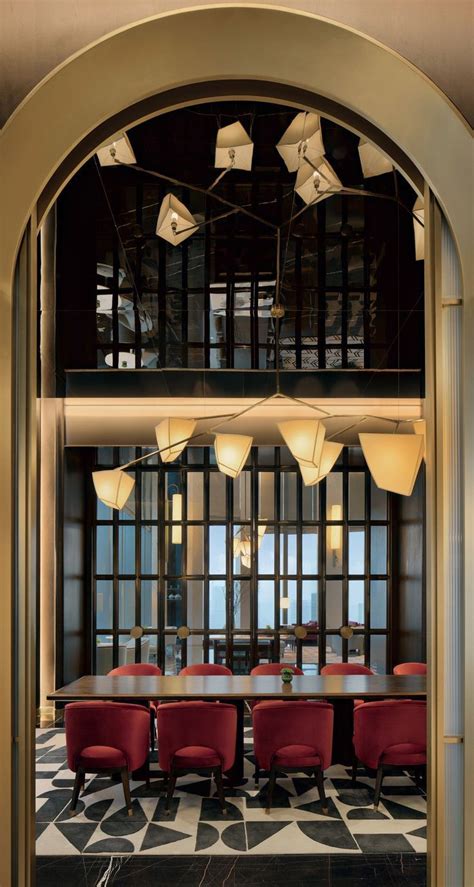 An Arched Doorway Leads To A Dining Room With Red Chairs And White