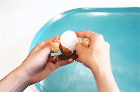 Women`s Hands Clean a Boiled Egg in the Kitchen. the Process of ...