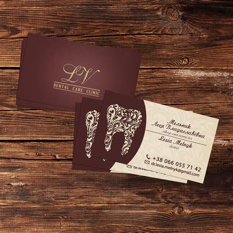two business cards sitting on top of a wooden table next to an envelope ...