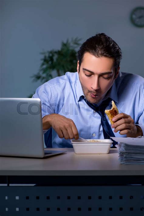 Hungry Employee Working Late In The Office Stock Image Colourbox