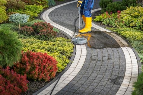 Premium Photo Worker Power Washing Residential Garden Pathway Using