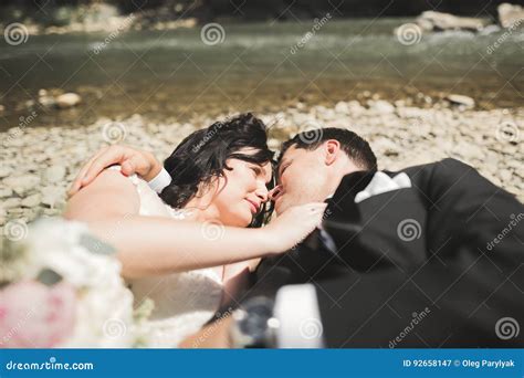 Beautifull Wedding Couple Kissing And Embracing Near The Shore Of A