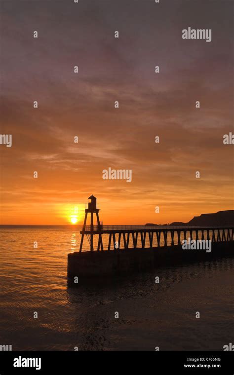 Whitby Harbour wall at sunset Stock Photo - Alamy