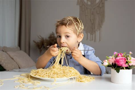 Cute Preschool Child Blond Boy Eating Spaghetti At Home Making A