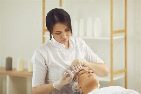 Woman Dermatologist Making Anti Aging Botox Filler Injection To Womans Forehead Stock Image