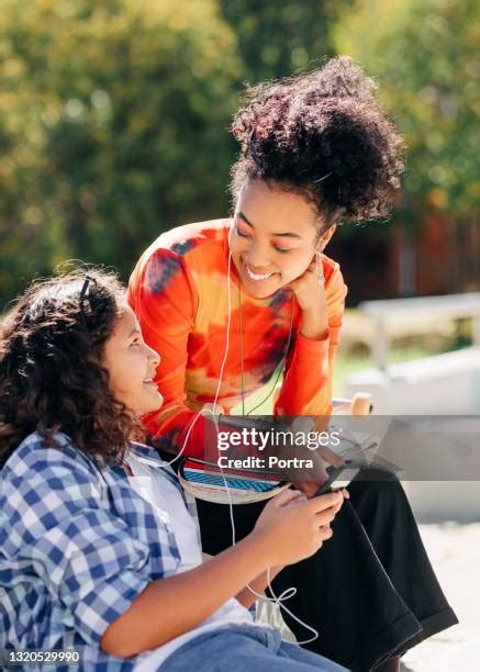 Two Preteen Girls Sharing Earphones Photos And Premium High Res