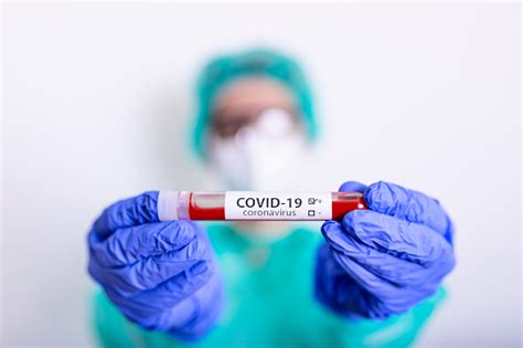 코로나 바이러스 Covid 19 외과 마스크와 여성 의사의 손에 감염된 혈액 유리병과 빛 코로나 바이러스 Covid 19