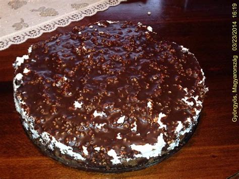 A Chocolate Cake With White Frosting And Sprinkles Sitting On A Table