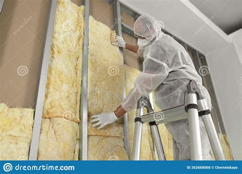 Worker Insulating Wall Using Ladder Indoors Low Angle View Stock Photo