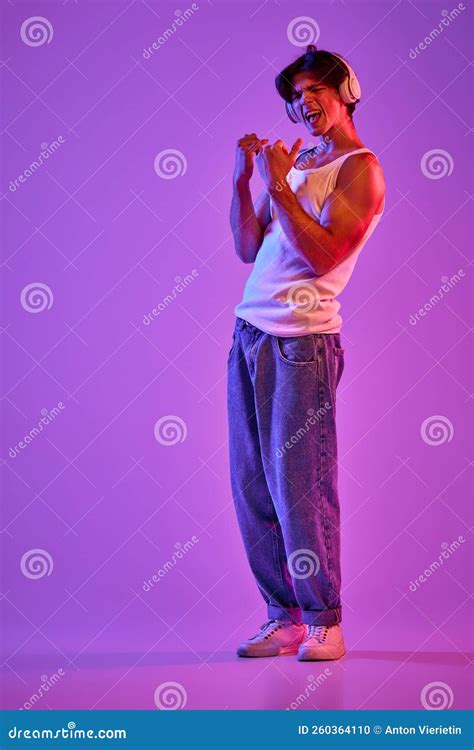 Portrait Of Young Muscular Man In White T Shirt Singlet Listening To