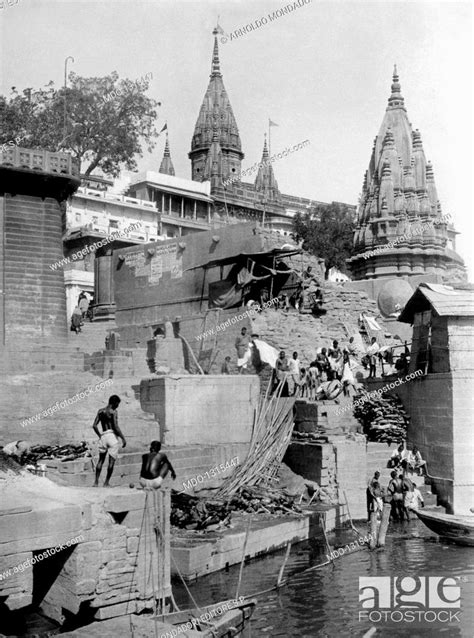 Funeral rites by the Ganges shore. Indian people attending a funeral ...