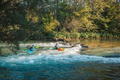 Kayakers Paddling And Maneuvering On The River Going Under The Bridge