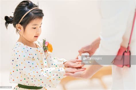 Mother Cleaning Her Daughers Hands With Wet Alcohol Tissue To Protect