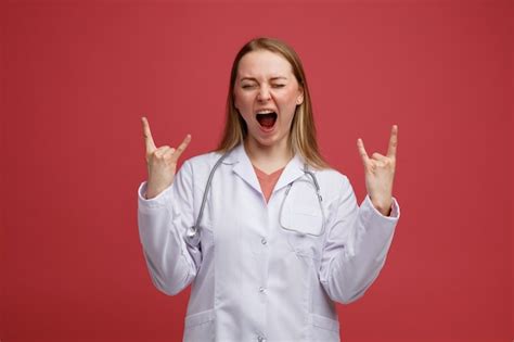 Jeune femme blonde agressive médecin portant une robe médicale et un stéthoscope autour du cou