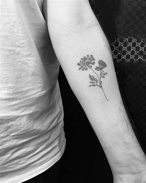 Two People With Tattoos On Their Arms And One Has A Small Flower Tattoo