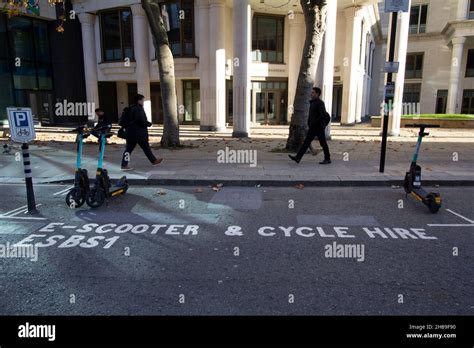 Two Lone Tier Electric Scooters In Partially Empty Scooter And Cycle