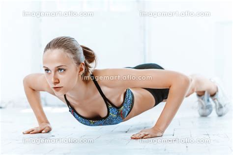 Beautiful slim brunette doing some push ups a the gymの写真素材 110471367