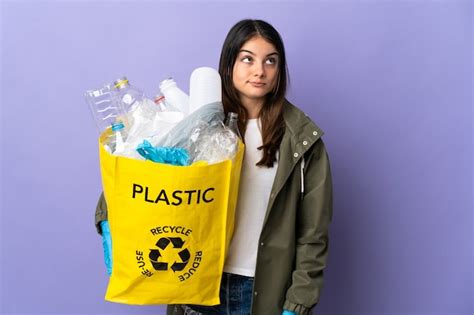 Mujer sosteniendo una bolsa llena de botellas de plástico para reciclar