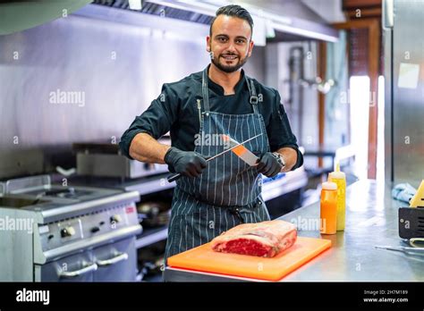 Chef sharpening knife for cutting meat in commercial kitchen Stock ...