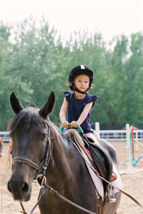 "Cute Little Girl Riding Horse" by Stocksy Contributor "MaaHoo" - Stocksy