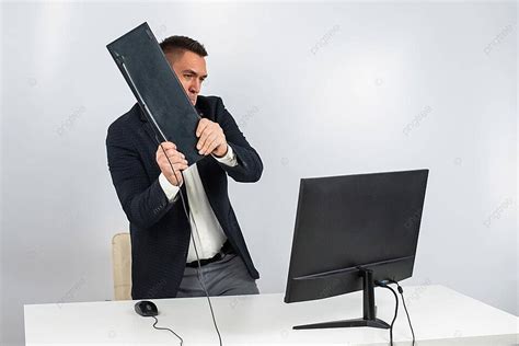 An Angry Man Smashes Keyboard And Monitor At Work Photo Background And