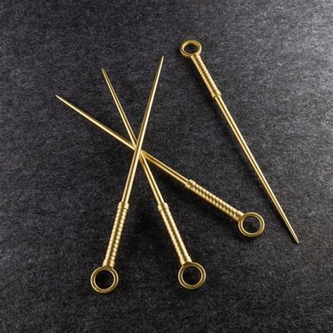 Four Pairs Of Knitting Needles Sitting On Top Of A Black Table Next To