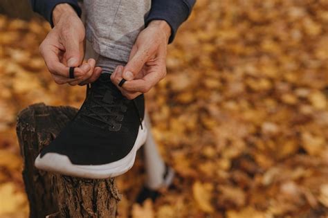 Premium Photo Crop Sportsman Tying Laces On Running Shoes While