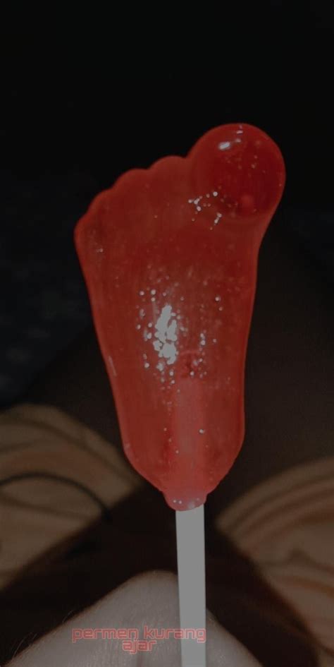 An Orange Lollipop On A Stick In Someone S Hand