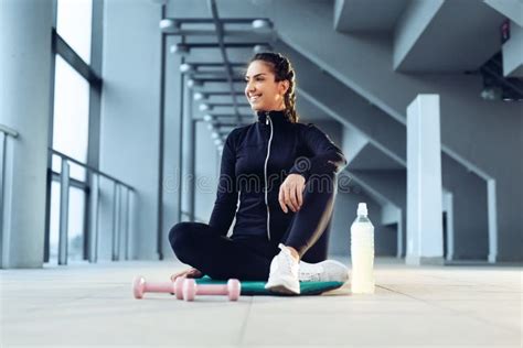 Sport Woman Sitting And Resting After Workout Or Exercise In Fitness