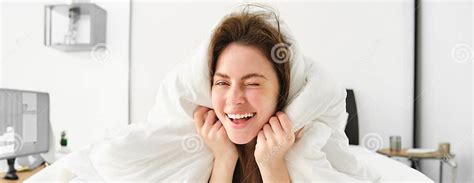 Portrait Of Gorgeous Smiling Woman Lying In Bed Covered In Duvet Has