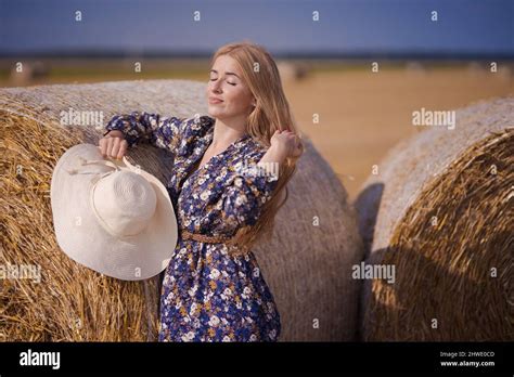 Une Jeune Fille Blonde Aux Cheveux Longs Dans Un Chapeau Blanc Se Repose Et Pose Pr S Des Gerbes