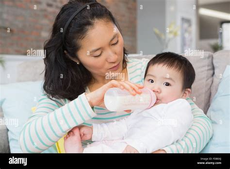 Mother Giving Milk In Bottle To Her Daughter Stock Photo Alamy