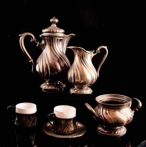 A Silver Tea Set On A Black Table