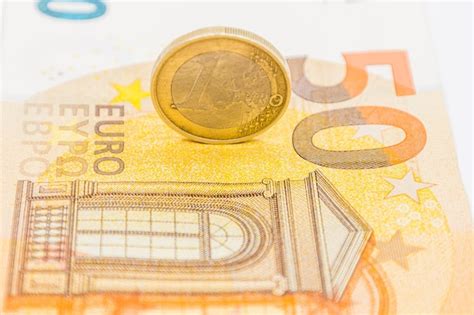 Uma moeda do euro na cédula da nota de 50 euros Foto Premium