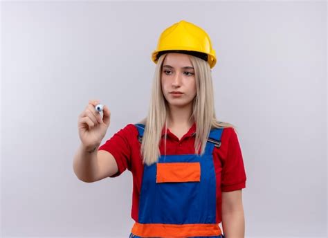 Sérieusement à la jeune fille blonde ingénieur constructeur en écriture uniforme avec un
