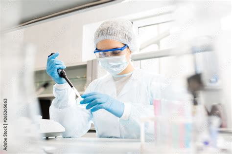 Serious Concentrated Female Microbiologist In Sterile Clothing And