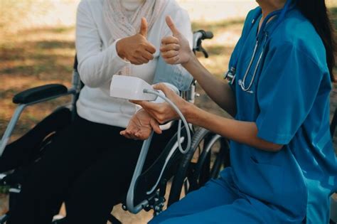 Enfermera Con Un Anciano En Silla De Ruedas En El Parque Foto Premium