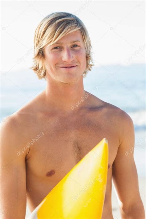 Handsome Man With His Surfboard At The Beach Stock Photo