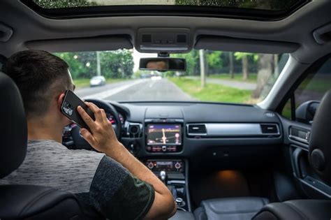 Premium Photo | Businessman talking on cell phone while driving