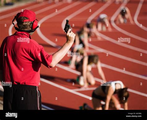 Race Official Holding A Starting Gun At The Beginning Of A Track Event