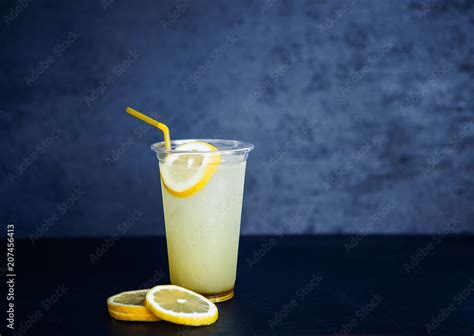 Lemon Lemonade In The Plastic Cup On The Black Background Stock Photo