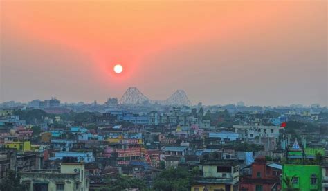 the sun is setting over a city with lots of tall buildings and colorful ...