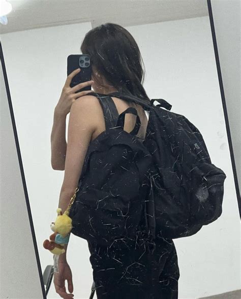 A Woman Is Taking A Selfie In The Mirror With Her Back To The Camera