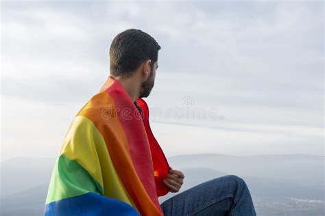 Hombre Sentado Con Una Bandera Gay Mirando El Horizonte Imagen De Archivo Imagen De Amante